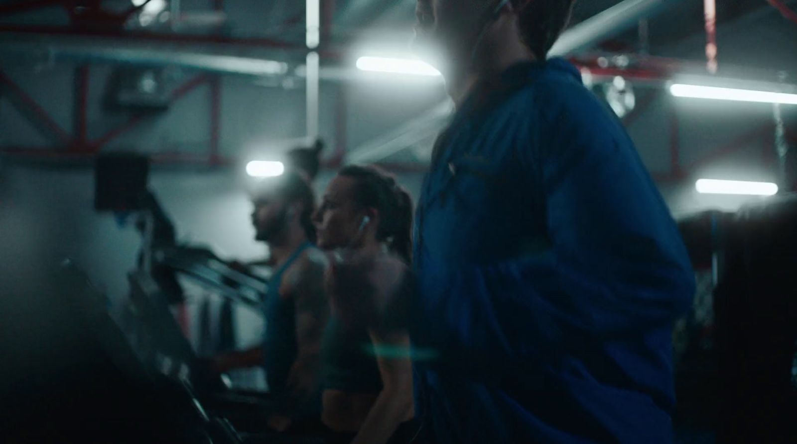 a group of people on treadmills in a gym