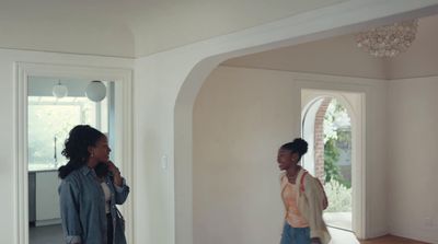 a couple of women standing in a living room