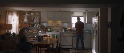 a man standing in a kitchen next to a table