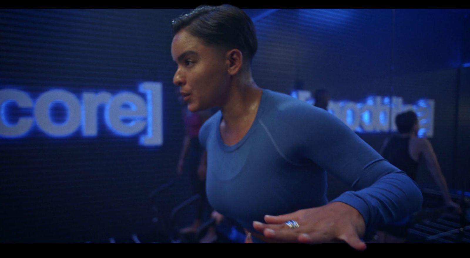 a woman in a blue shirt standing in front of a sign