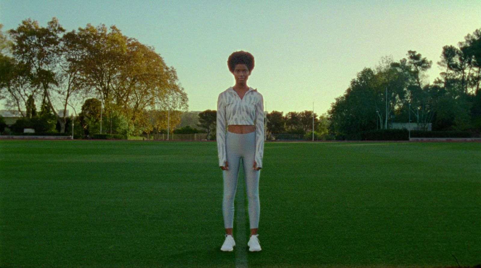 a woman standing on top of a lush green field