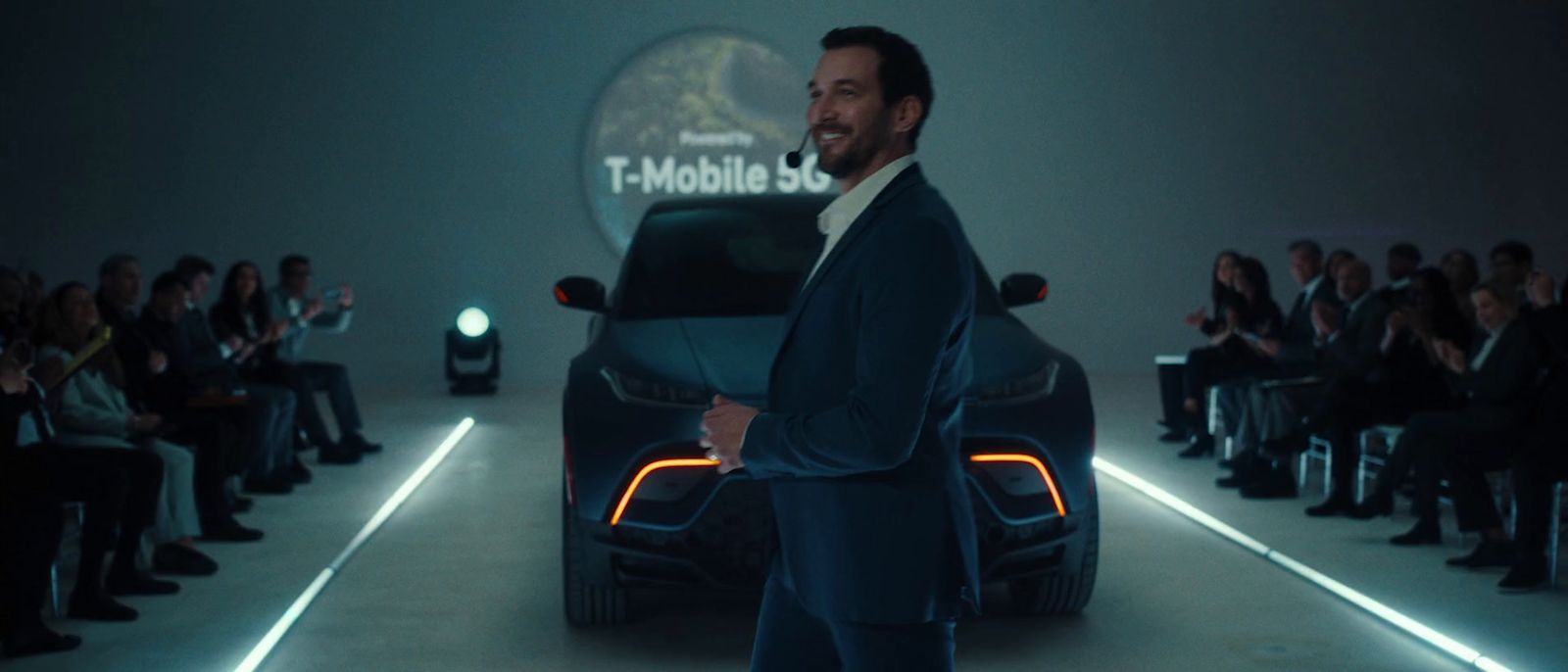 a man in a suit standing in front of a car