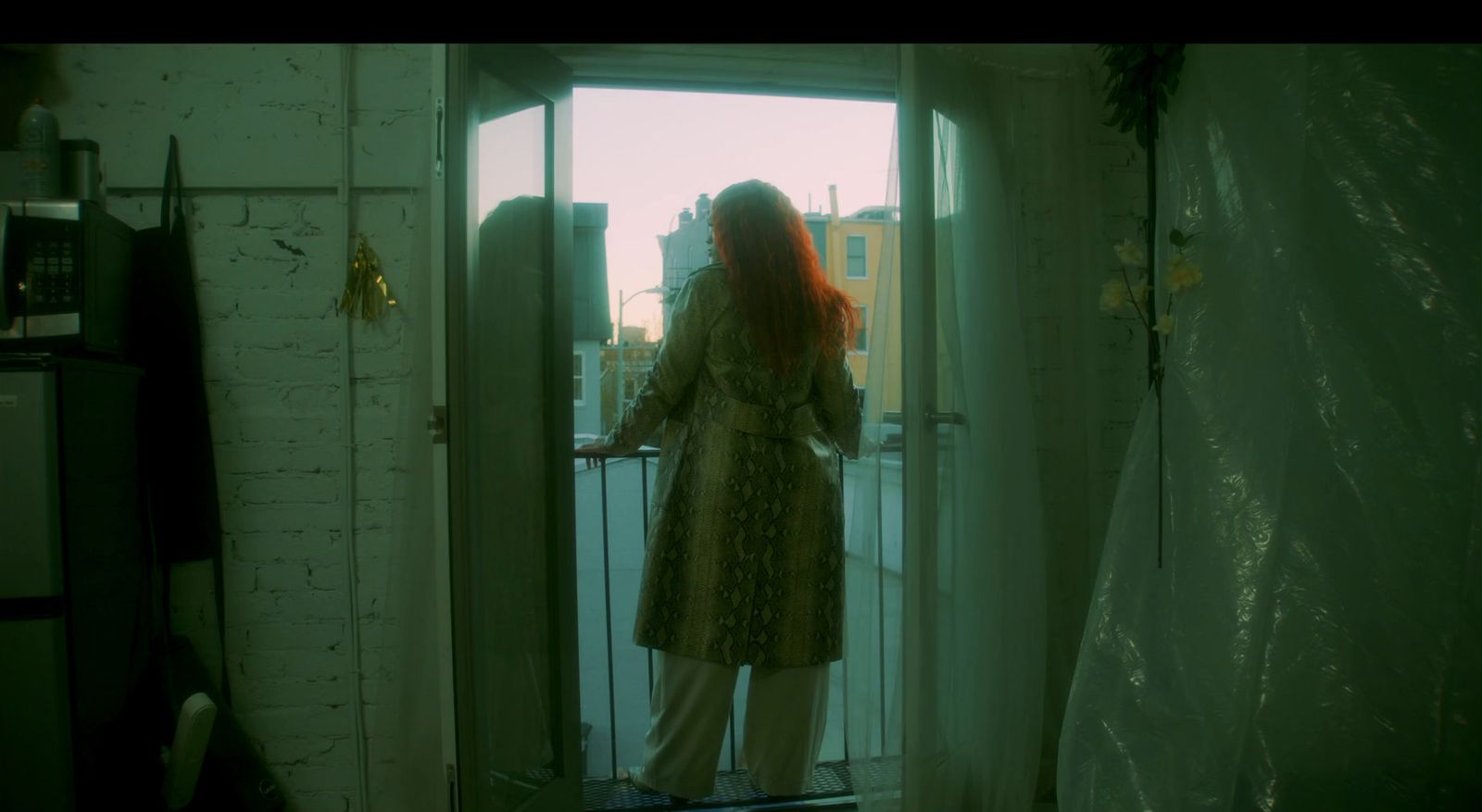 a woman standing on a balcony looking out the window