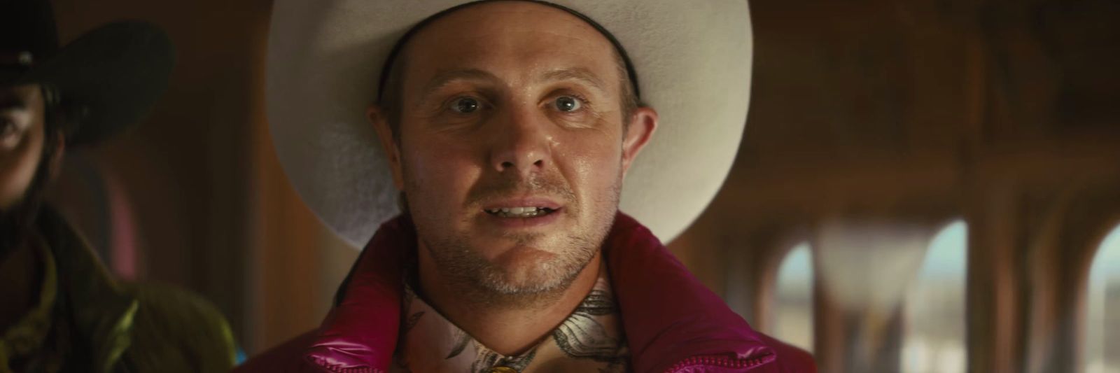 a man wearing a cowboy hat and a red jacket