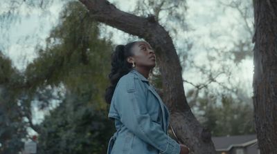 a woman standing in front of a tree