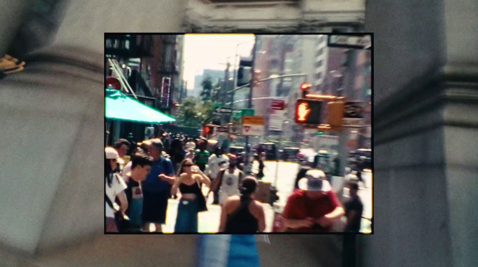 a crowd of people walking down a street next to tall buildings