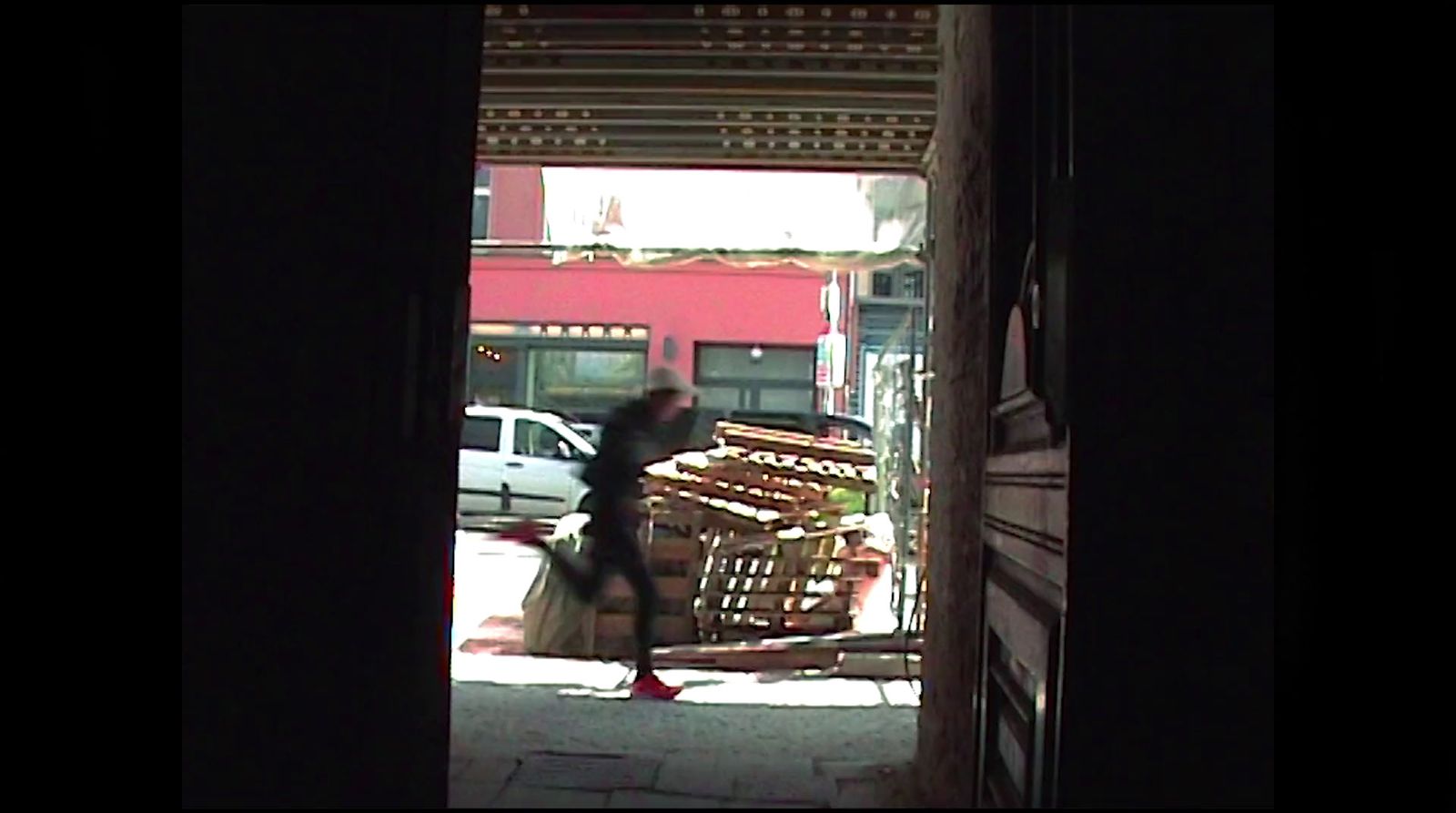 a woman walking down a street past a store