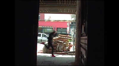 a woman walking down a street past a store