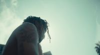 a man with dreadlocks standing in front of a building