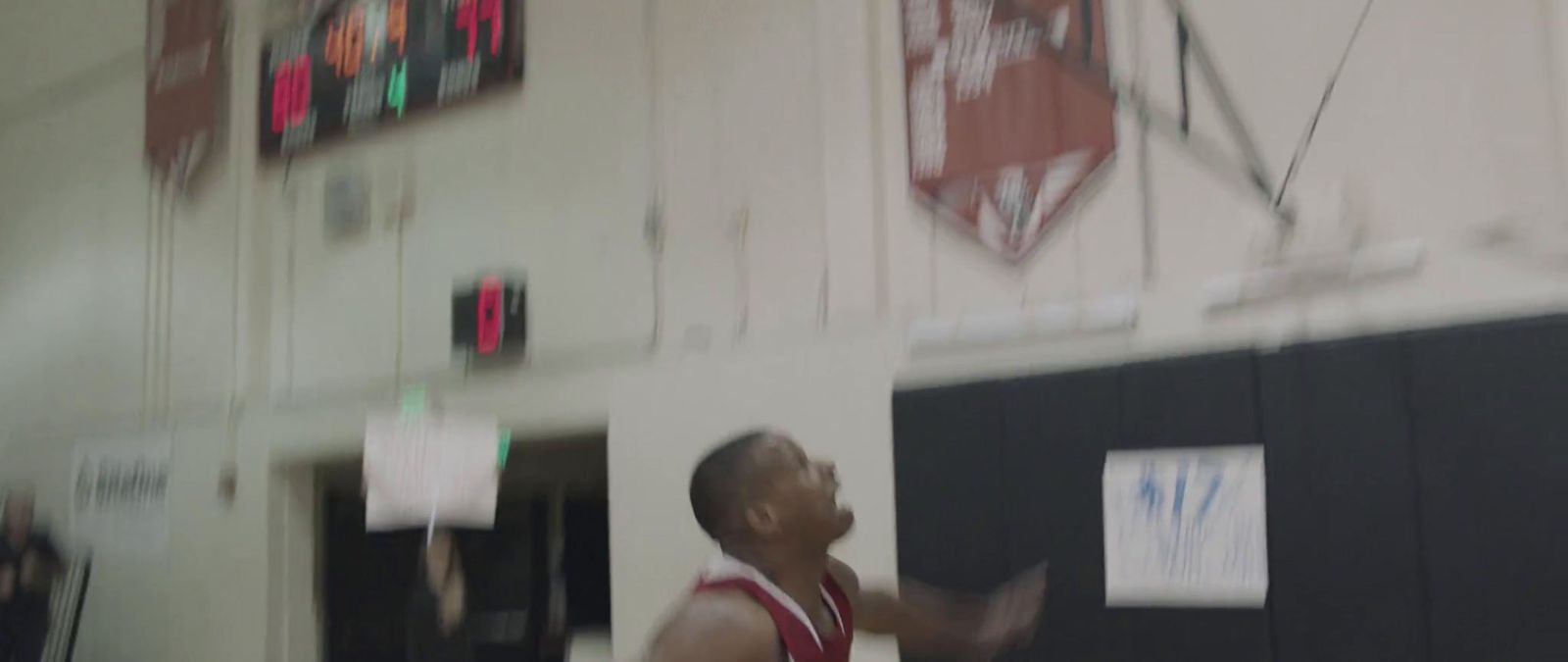 a man in a red and white uniform playing a game of basketball