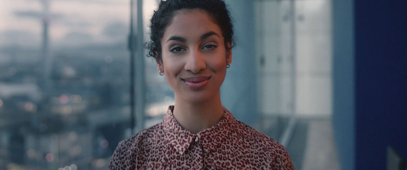 a woman standing in front of a window smiling