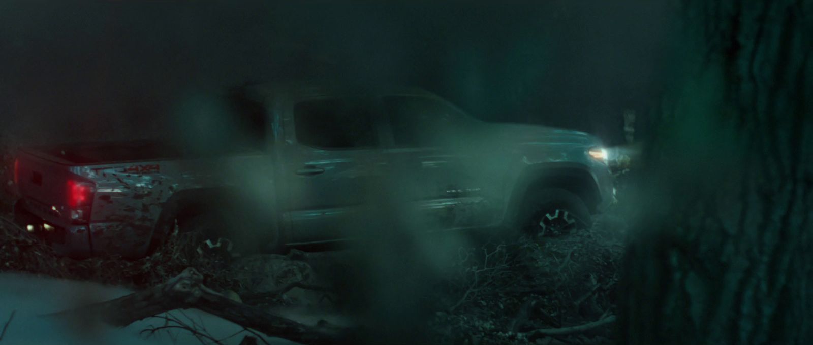 a truck is parked in the woods at night