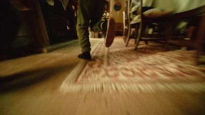 a blurry photo of a person walking on a wooden floor