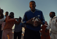 a man holding a ball in front of a group of people