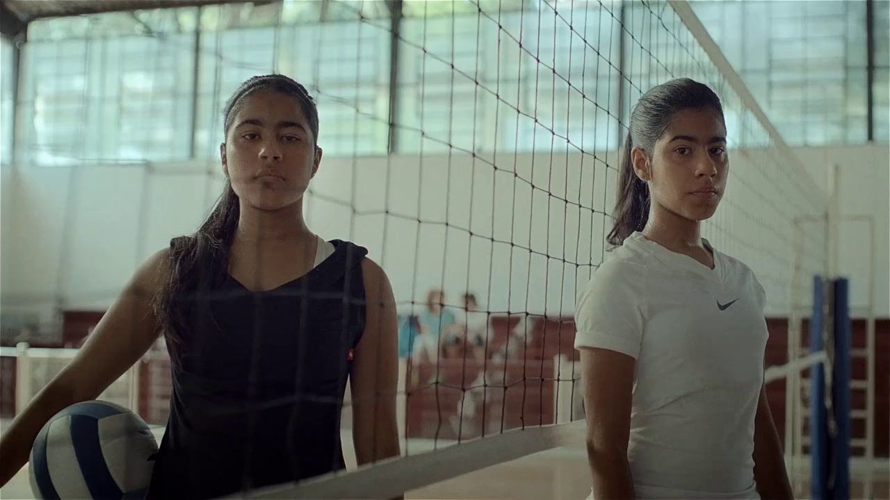 a couple of women standing next to each other near a net