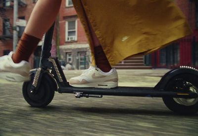 a person riding a scooter on a city street