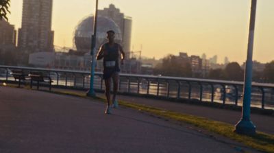 a man running down a street next to a bridge