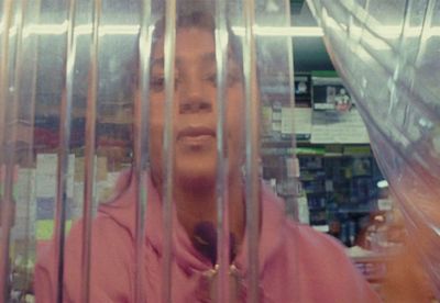 a woman in a pink hoodie behind bars