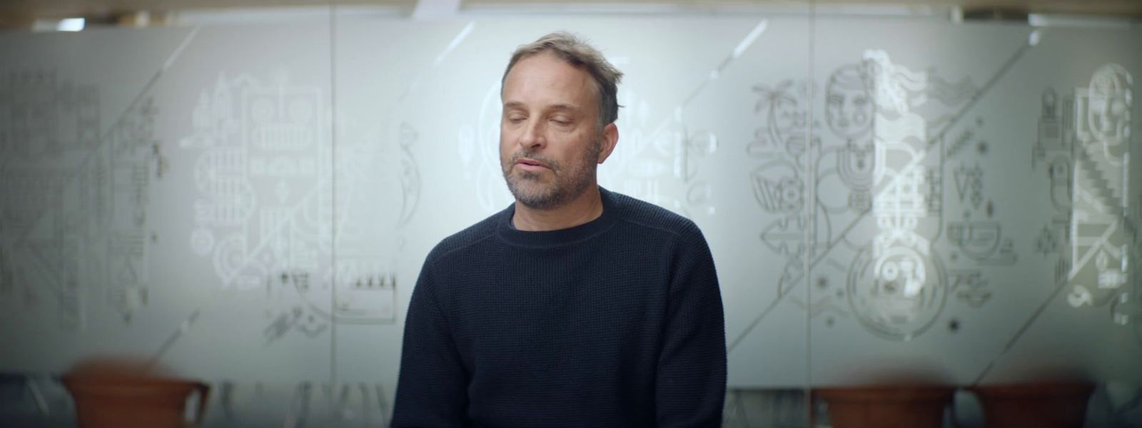 a man standing in front of a glass wall