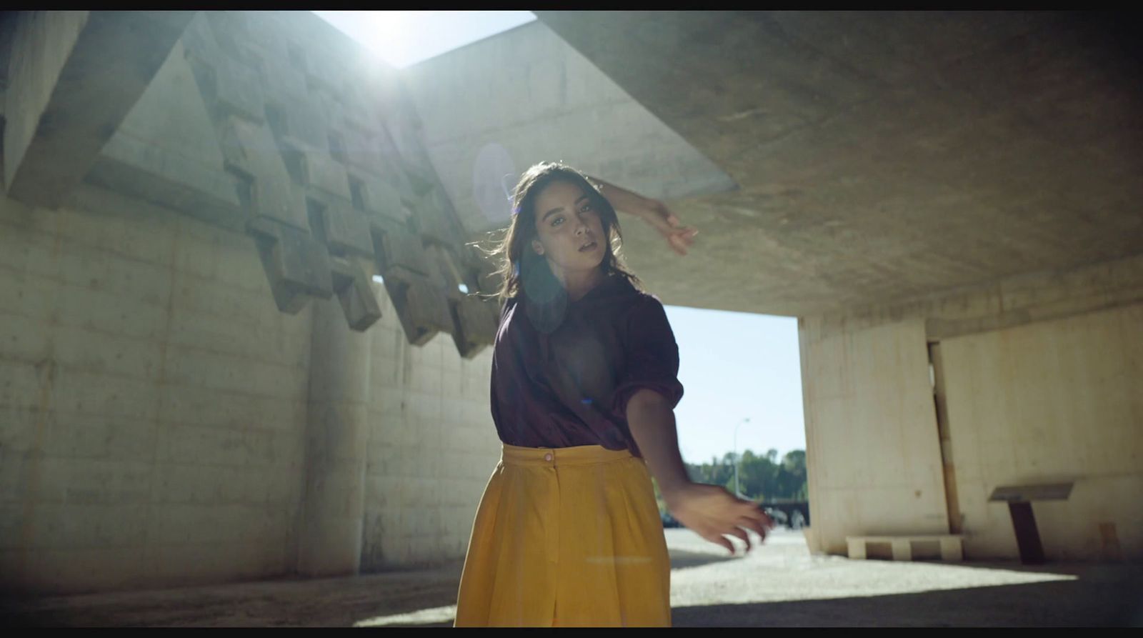 a woman in a yellow skirt is throwing a frisbee