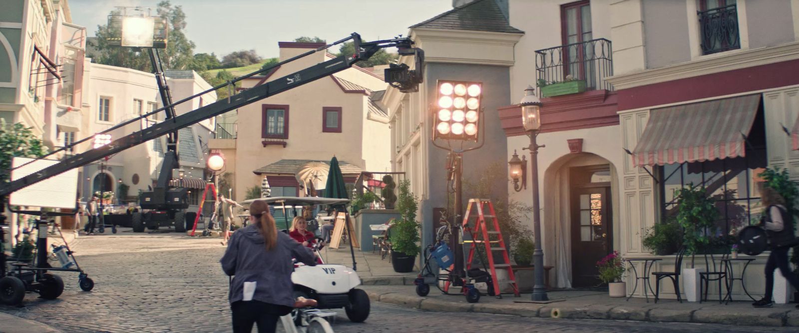 a man standing next to a baby carriage on a cobblestone street