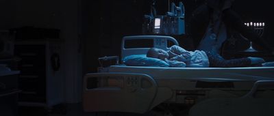 a person laying in a hospital bed in the dark