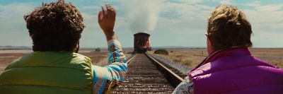 a couple of people that are sitting on a train track