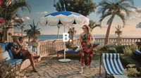 a woman in a colorful dress is walking by a pool