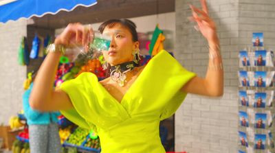 a woman in a yellow dress standing in front of a store