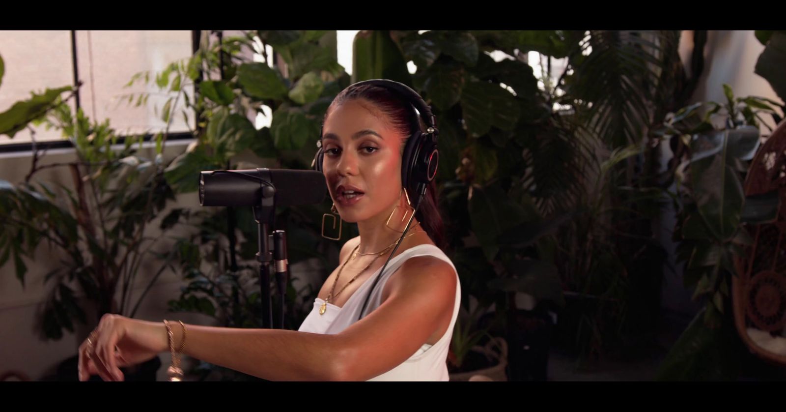 a woman with headphones on in front of a microphone