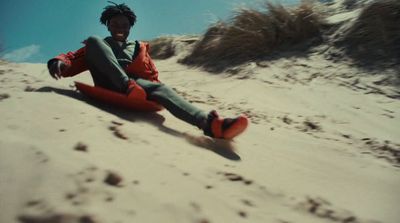 a man sitting on top of a sandy beach