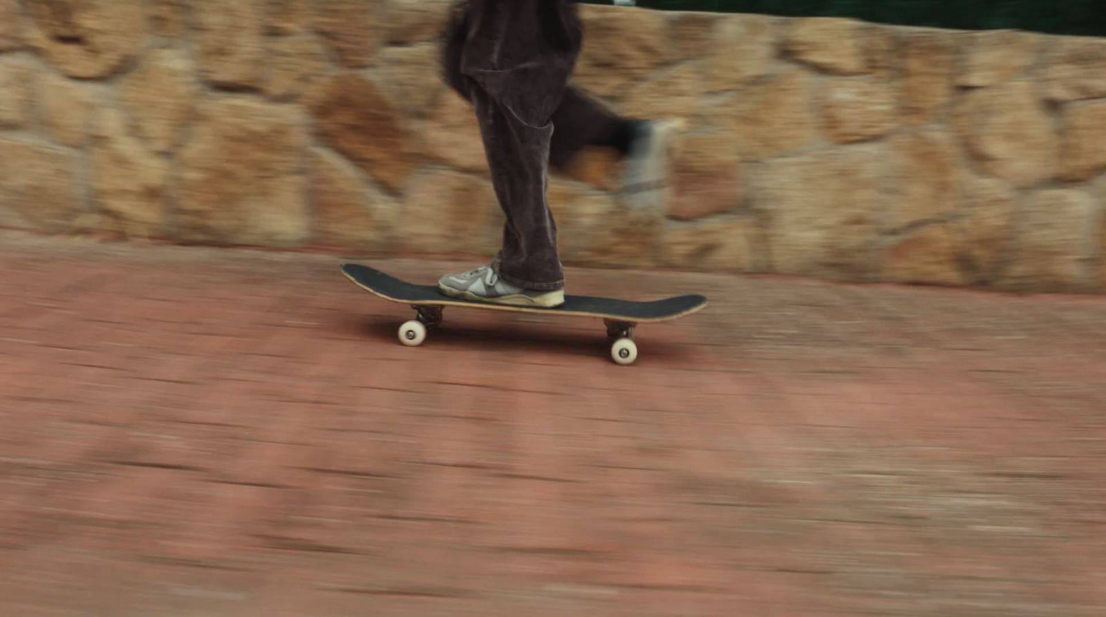 a person riding a skateboard on a brick road