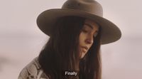a woman with long hair wearing a hat