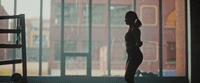 a woman is standing in front of a window