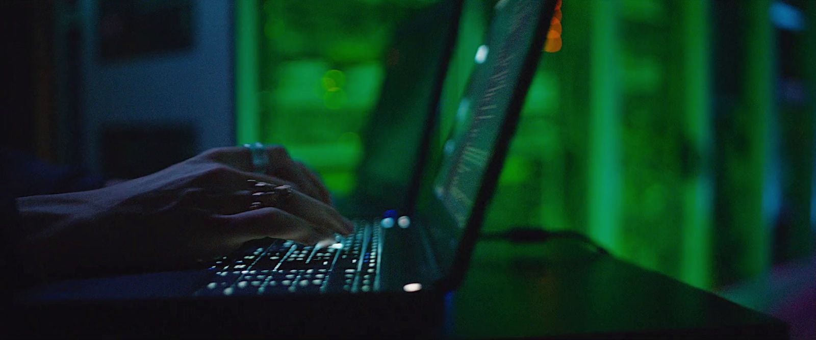 a person typing on a laptop in a dark room