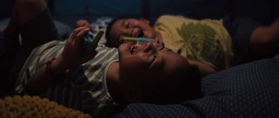 a couple of kids laying on top of a bed