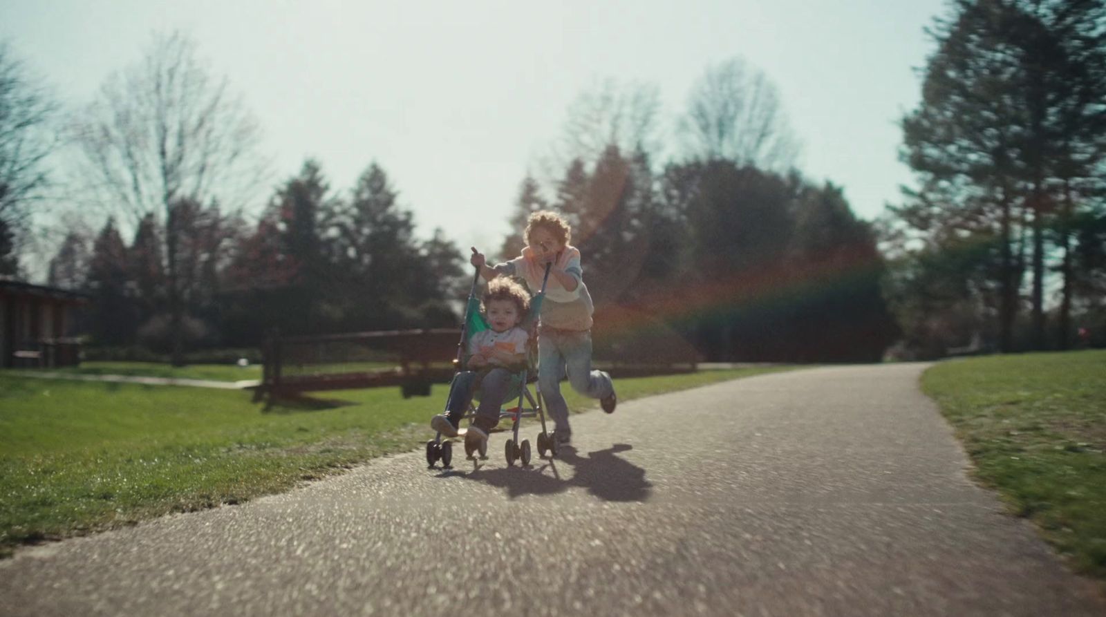 a couple of kids riding on the back of a stroller