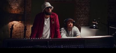 two men standing next to each other in front of a keyboard