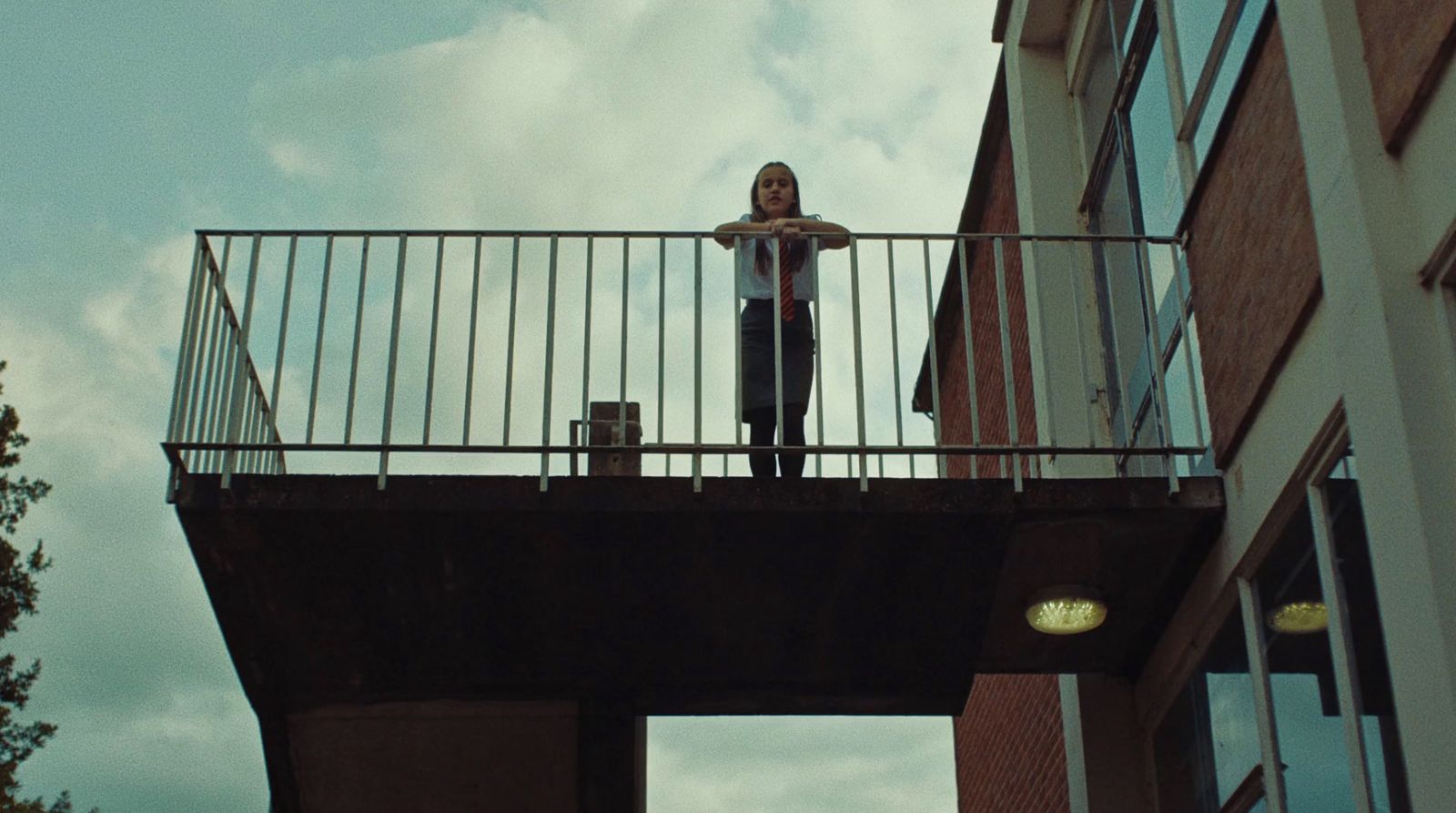 a woman standing on a balcony with a suitcase