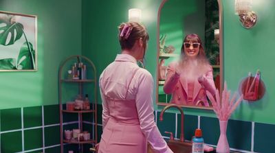 a woman standing in front of a mirror in a bathroom