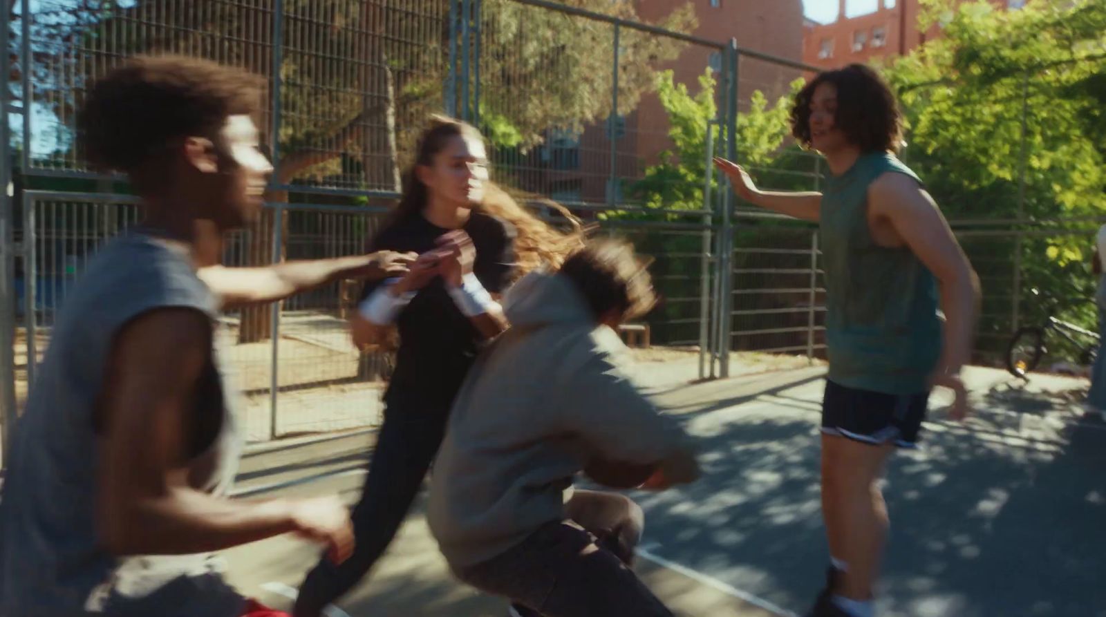 a group of young men and women playing a game of basketball