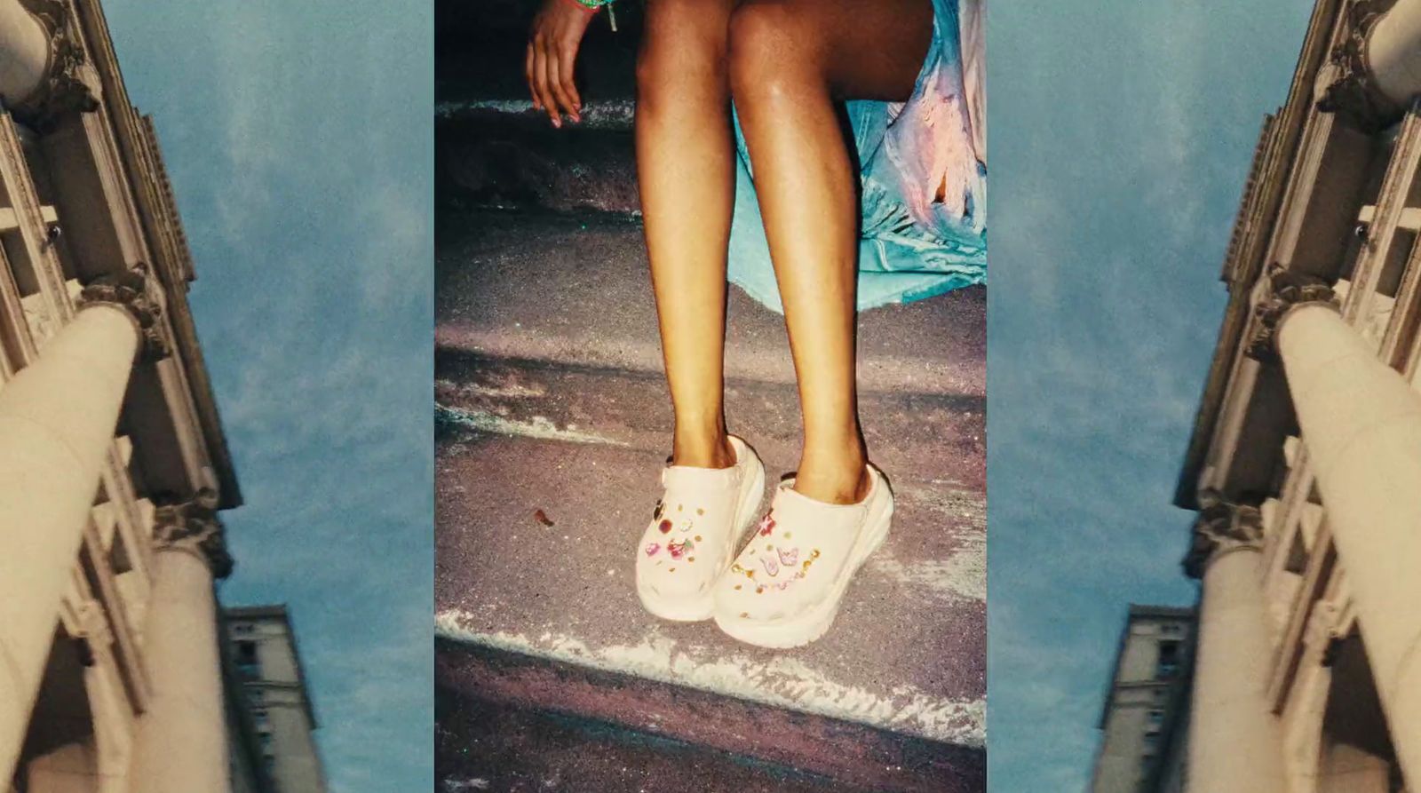 a woman sitting on a ledge with her legs crossed