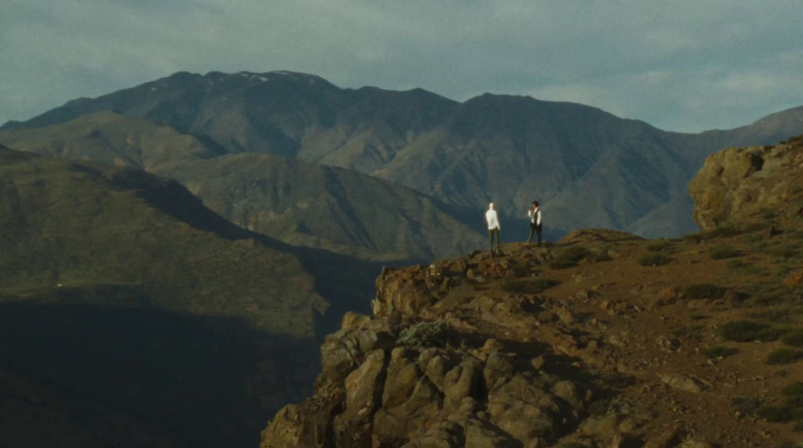 a couple of people standing on top of a mountain