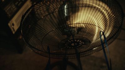 a fan sitting on top of a table next to a microwave