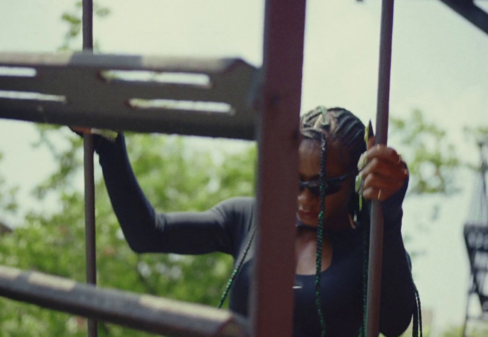 a woman holding onto the bars of a playground