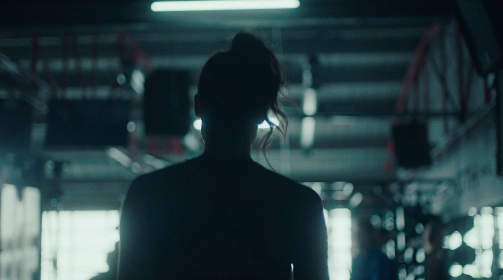 a woman standing in a dark room with her back to the camera