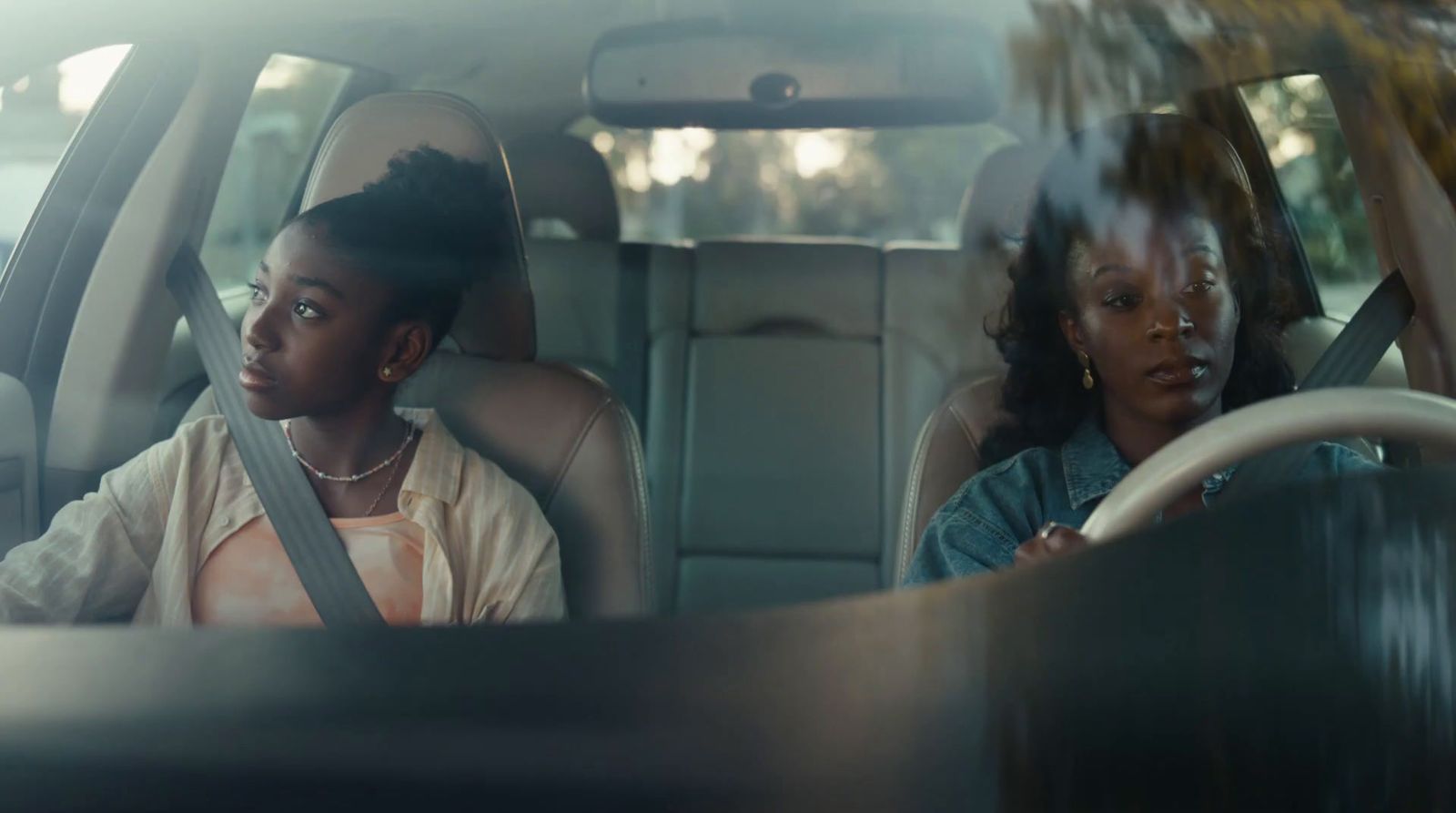 two women sitting in the back seat of a car