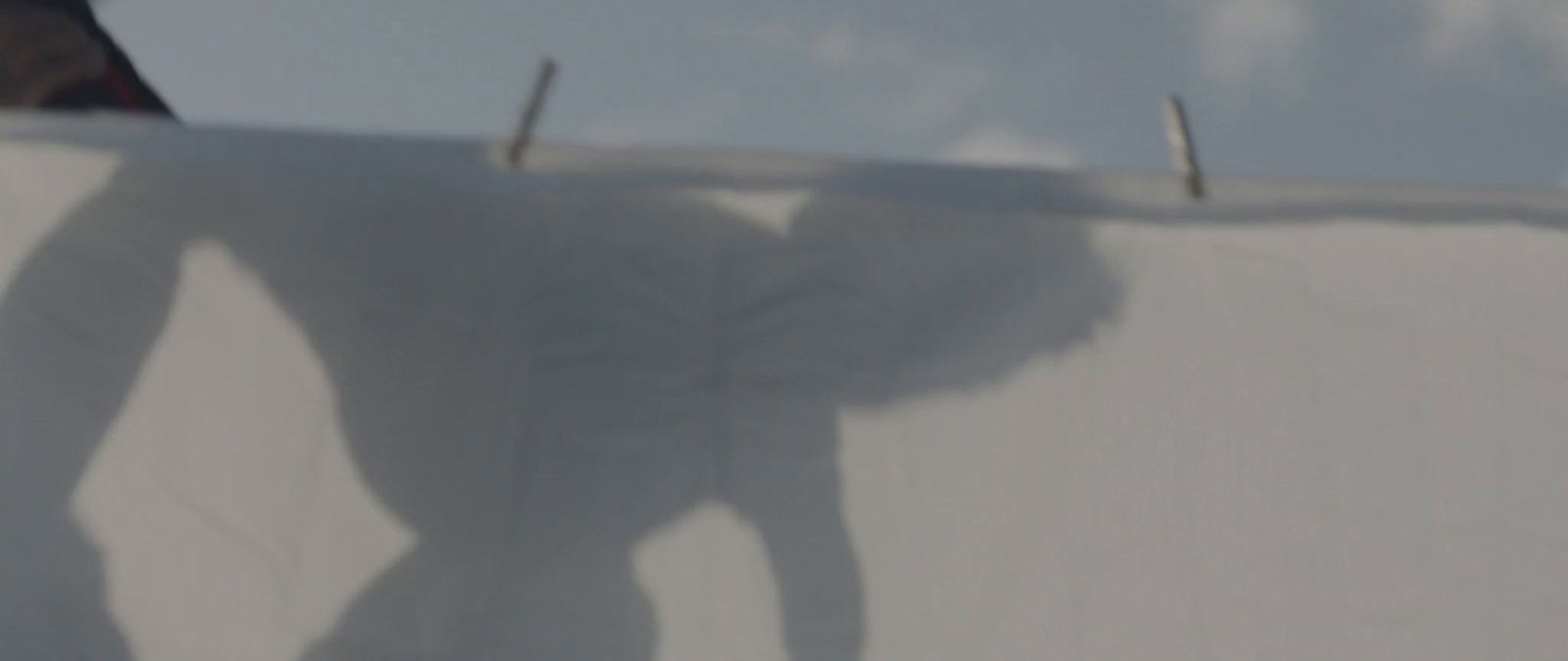 a man riding a snowboard down the side of a snow covered slope