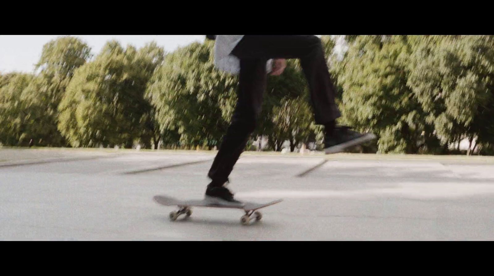 a man riding a skateboard down the middle of a parking lot