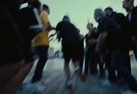 a blurry photo of a group of people on a boardwalk